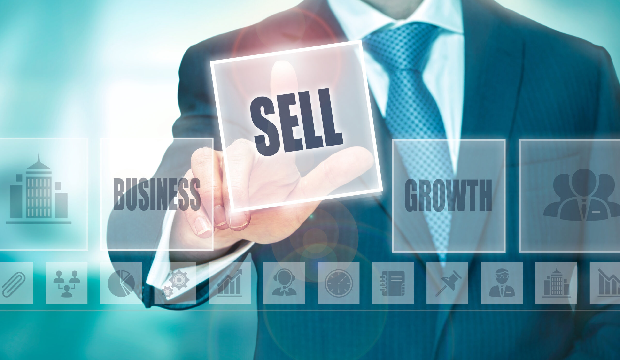 The torso of a man in a suit touching a highlighted graphic square that says "SELL" next to other graphics.