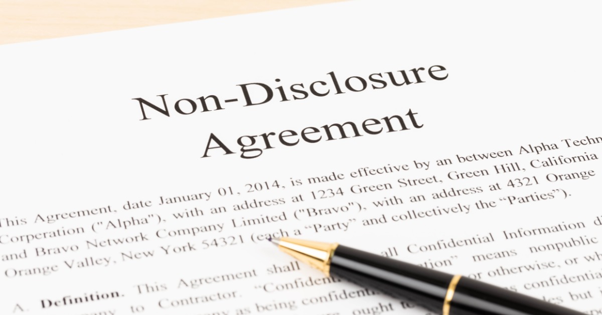 A close-up of a white document with "Non-Disclosure Agreement" printed at the top with a black pen underneath it.